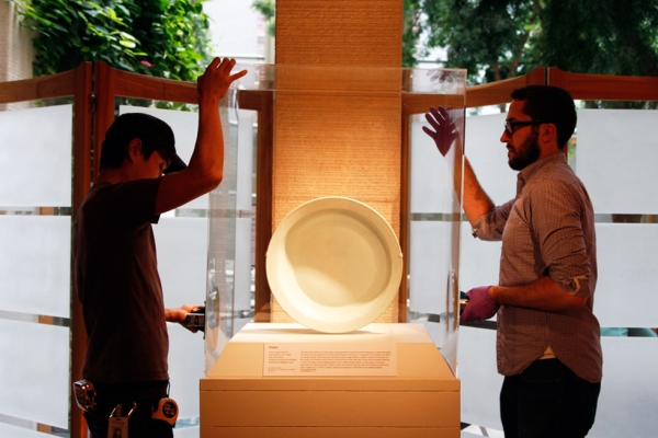 Hiroaki Sato (L) and John Ros (R) place a protective cover over a work on display. (Tahiat Mahboob/Asia Society)