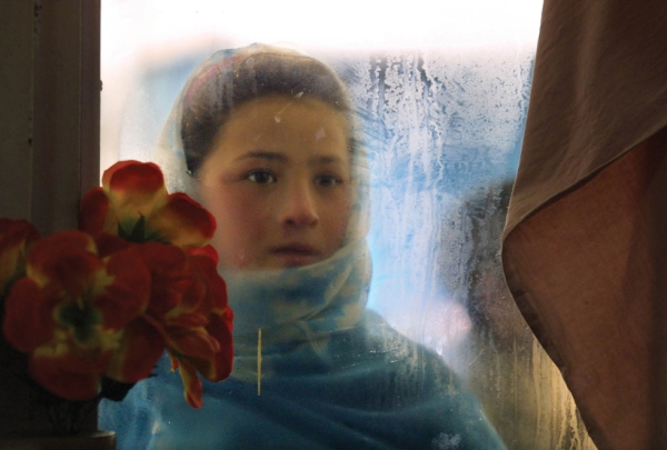 Kabul, 2002: Switan, age ten, looks into the window of the Herat restaurant. She gazes at people eating with the hopes of getting leftovers and makes 50,000 to 70,000 Afghani ($2.50 U.S.) per day begging from foreigners. (Paula Bronstein/Getty Images)