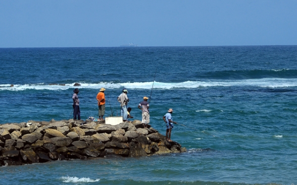 Fishermen stand on the end of a rock jetty in Colombo, Sri Lanka on September 30, 2013. (Lakruwan Wanniarachchi/Getty Images)