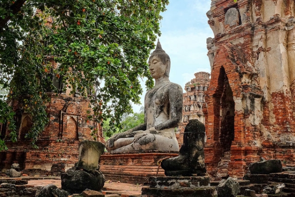 Broken statues and red ruin walls surround a giant Buddha statue in Ayutthaya, Thailand on October 4, 2013. (C. Reid Taylor/Flickr)