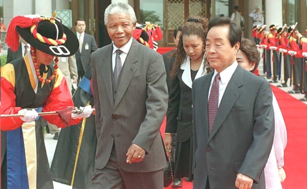 South African President Nelson Mandela (C) and South Korean President Kim Young-Sam (R) pass a South Korean honor guard during a welcoming ceremony at the Blue House in Seoul on July 7, 1995. (Pool/AFP/Getty Images)