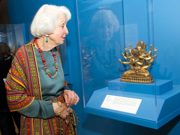 Exhibition supporter Lisina Hoch views an exquisite 15th-century Guhyasamaja gilt copper sculpture in the "Golden Visions of Densatil" exhibition. (Elena Olivo/Asia Society)