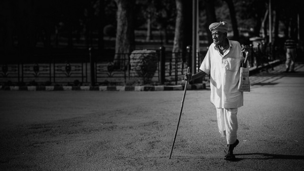 An old man goes out walking with a stick on the streets of Bangalore, India on March 29, 2014. (Soumya Geetha/Flickr)