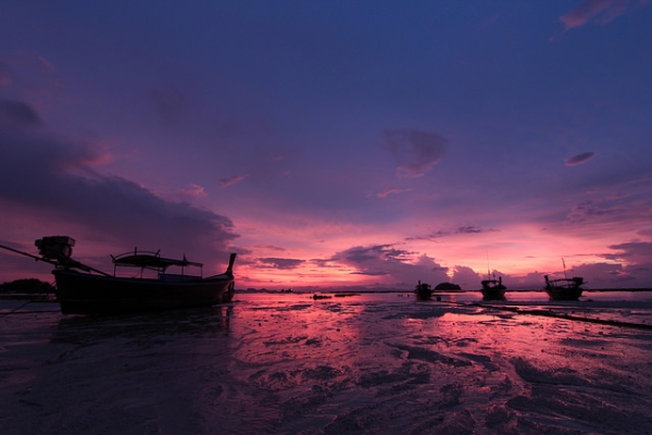 A sunrise over long tail boats paints the sky purple in Koh Lipe, Thailand on April 1, 2014. (Bambi Corro III/Flickr)