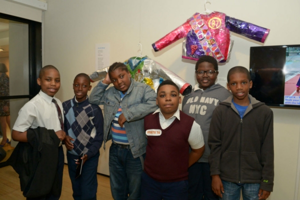 Student artists pose in the gallery in front of Futuristic Prototype Suit 87 – Type 1, 2, 3, & 4. (Elsa Ruiz)