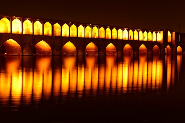 Illuminated arches of a bridge create fiery reflections in the water in Iran on April 22, 2015. (Luca Cerabona/Flickr)