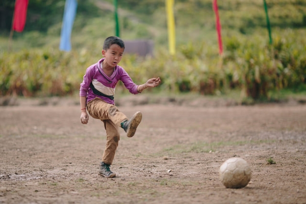 A little boy photographed in the midst of playing soccer in India on May 27, 2015. (alcan_/flickr)