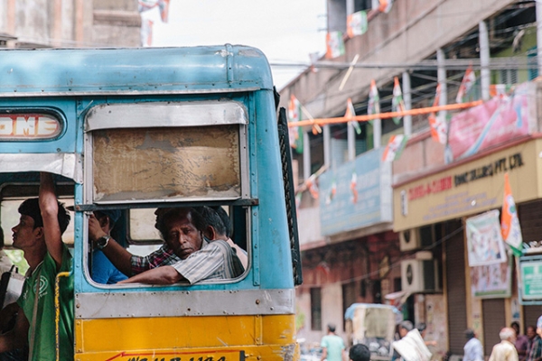 A man looks out the window of a bus in Kolkata, India on May 27, 2015. (alcan_/Flickr)