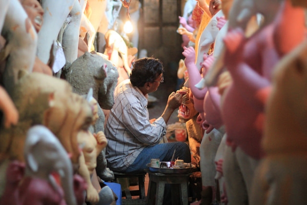 A potter hard at work painting a long row of religious statues made of clay in Kolkata, India on October 10, 2015. (@DaskBlogs/Flickr)