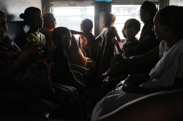 Indian women and children wait inside a darkened train carriage at a railway station in New Delhi on July 31, 2012. (Roberto Schmidt/AFP/GettyImages)