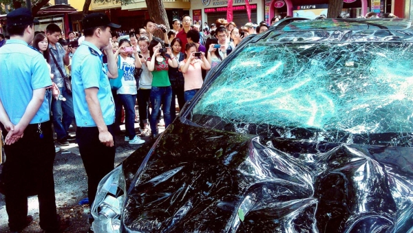 People take pictures of a Japanese car damaged during a protest against Japan's 'nationalizing' of the disputed Diaoyu Islands, also known as Senkaku Islands in Japan in Xi'an, northwest China's Shaanxi province, on September 15, 2012. (AFP/GettyImages)
