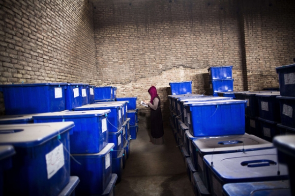 Afghan election employee, Forouzan Barez checks the plastic boxes containing election material at a warehouse prior to transportation to the polling centers, in the northwestern city of Herat on April 3, 2014. (Behrouz Mehri/AFP/Getty Images)
