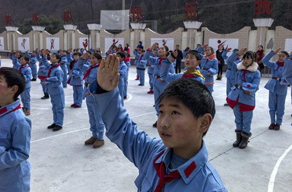 January 21, 2015, children dressed in uniform sing after raising the national flag at the Beichuan Red army elementary school. (Fred Dufour/AFP/Getty Images)