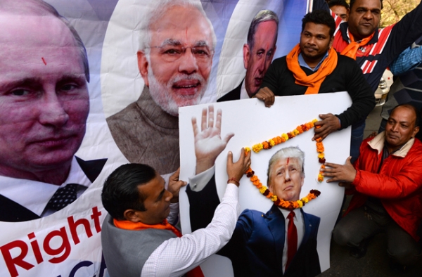 Right-wing activists of India's Hindu Sena party pose with a poster of Russian President Vladimir Putin, (L), Indian Prime Minister Narendra Modi (2L) and US President-elect Donald Trump (R) during an event in New Delhi on January 19, 2017.(Sajjad Hussain/AFP/Getty Images)