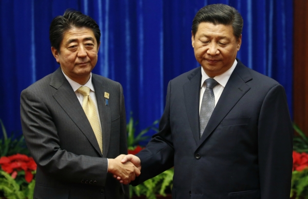 Japan's Prime Minister Shinzo Abe shakes hands with China's President Xi Jinping (R), during their meeting at the Great Hall of the People, on the sidelines of the Asia Pacific Economic Cooperation (APEC) meetings, November 10, 2014 in Beijing, China. (Kim Kyung Hoon/Pool-Getty Images)