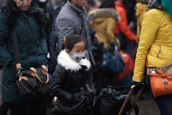 A Chinese girl with a face mask prepares to travel at the Beijing Railway Station in Beijing, China on January 31, 2013. (Lintao Zhang/Getty Images)