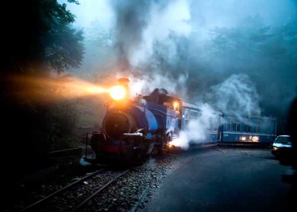 In India, the Darjeeling mountain train puffs through mist on a winter’s evening. (Amos Chapple)