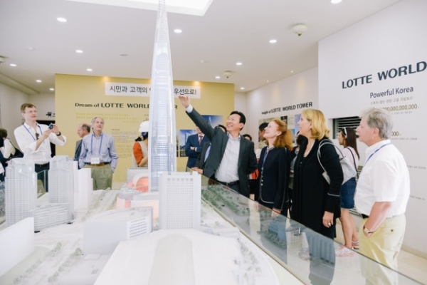Mr. Dong-Bin Shin, Chairman of the Korea Center and Chairman of the Lotte Group, shows off the plans for the new Lotte World Tower to Asia Society's global trustees. 