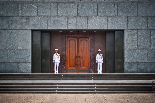 Two guards dressed in white flank the entrance to Ho Chi Minh's Mausoleum in Vietnam on June 8, 2015. (jev55/Flickr)