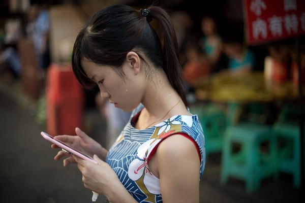 A woman examines her phone in Chongqing, China.