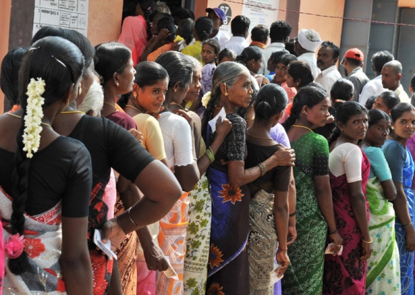 INDIA, MAY 13 - Women wait outside an election polling booth in Nagendra Mangalam, 135 kms east of Bangalore, to cast their votes in national elections. Some 400 million Indians voted in a month-long election that led to a major victory for the Congress Party. (Dibyangshu Sarkar/AFP/Getty Images)