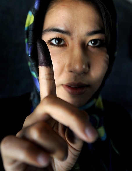 AFGHANISTAN, AUGUST 20 - An Afghan girl displays her finger marked with indelible ink after casting her vote at a polling station in Kabul. Afghans voted to elect a president for just the second time in their war-torn history as a massive security clampdown swung into action to prevent threatened Taliban attacks derailing the ballot. (Shah Marai/AFP/Getty Images)