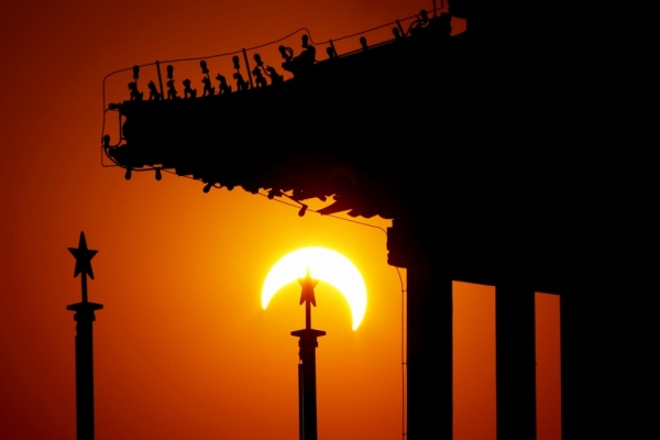 The moon began to obstruct the view of the sun from earth during a solar eclipse seen from Tian&apos;anmen Square in Beijing, China, on Jan. 15. The eclipse, which first became visible in the south Indian state of Tamil Nadu, was predicted to be the longest of its kind for the next 1000 years. (Feng Li/Getty Images)