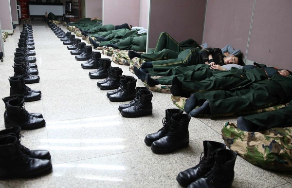 Paramilitary policeman sleep on the floors of a railway station on January 26, 2014 in Beijing, China. (ChinaFotoPress/Getty Images))