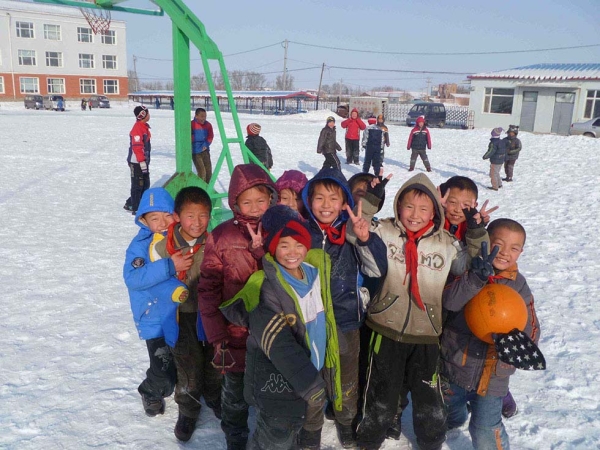 Wasteland's elementary students at recess in deep winter. The three-story school in the background was the tallest structure in Wasteland until the railway overpass was built. (Michael Meyer)