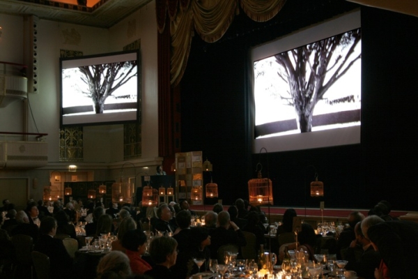 Guests view a sample of Iranian visual artist (and Cultural Achievement Award-winner) Shirin Neshat&apos;s video work during the dinner. (Bill Swersey/Asia Society)