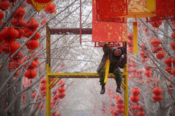 A worker puts the finishing touches on lantern decorations for Spring Festival celebrations at a park on January 24, 2014 in Beijing, China. (Wang Zhao/AFP/Getty Images)