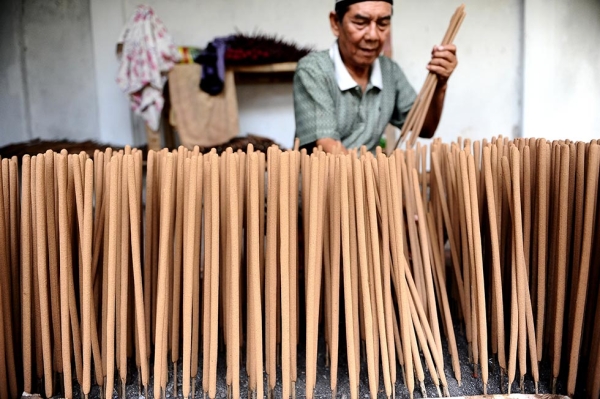 A man prepares incense sticks for drying in anticipation of increased orders for upcoming Lunar New Year festivities on January 18, 2014 in Malang, Indonesia. (Robertus Pudyanto/Getty Images)