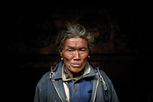 The winter monastery keeper stands for a portrait in the main hall of the monastery in Tetang. (Taylor Weidman)