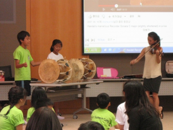 Renowned violinist and K21 member Youyoung Kim (R) leads a music class, with special accompanists on percussion. (Asia Society Korea Center)