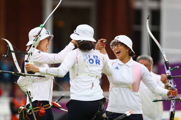 GOLD: South Korea's Hyeonju Choi (L), Bobae Ki (C) and Sung Jin Lee (R) celebrate winning the Women's Team Archery Gold medal match  on July 29, 2012. (Paul Gilham/Getty Images)