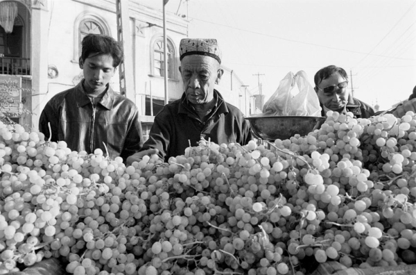 Men shop for grapes at a street market in Kashgar, Xinjiang. (Ryan Pyle)