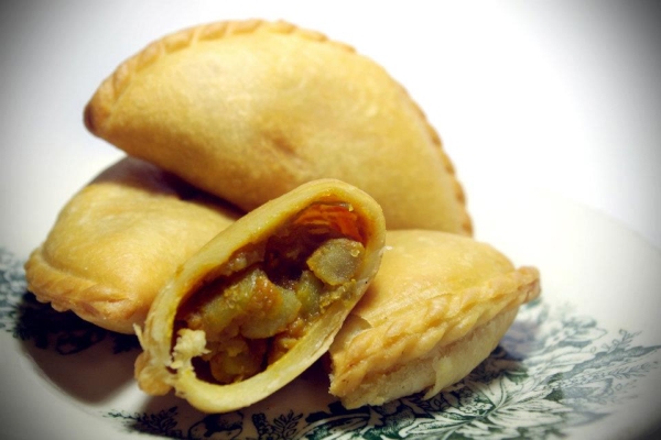 Curry puffs are deep fried fritters that resemble empanadas with curried potatoes and sometimes chili sardines. In Singapore, they are commonly sold by bicycle vendors or the back of vans. (Saki Yuen)