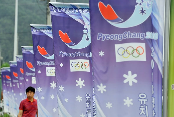 A man walks along a row of banners with the logo of South Korea's mountain resort of Pyeongchang, 180 kms east of Seoul, on July 7, 2011 after the mountain resort was picked to host the 2018 Winter Olympics. (Jung Yeon-Je/AFP/Getty Images) 