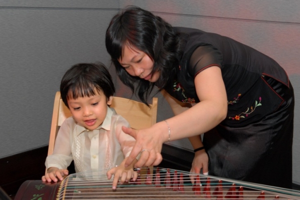An aspiring musician plays the guqin, a Chinese zither. (Elsa Ruiz/Asia Society)