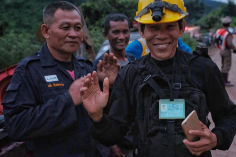 A rescuer at Thailand's Tham Luang cave complex smiles during an operation to rescue 12 boys and their soccer coach.