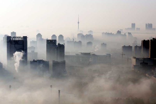An aerial view of buildings standing out amid haze engulfing Wuhan, central China's Hubei province on Dec. 3, 2009. China will need to invest up to 30 billion dollars a year to meet its goal of curbing greenhouse gas emissions, the state press said, citing an academic study. (STR/AFP/Getty Images)