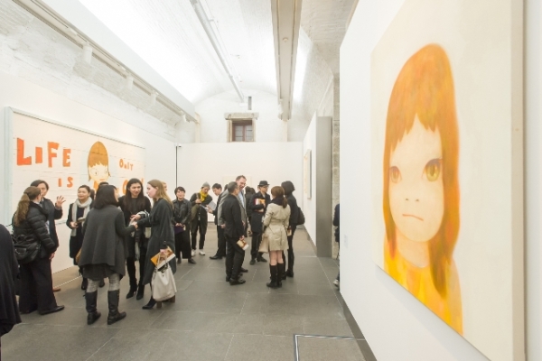 Guests viewing and discussing the works of Yoshitomo Nara at the opening.