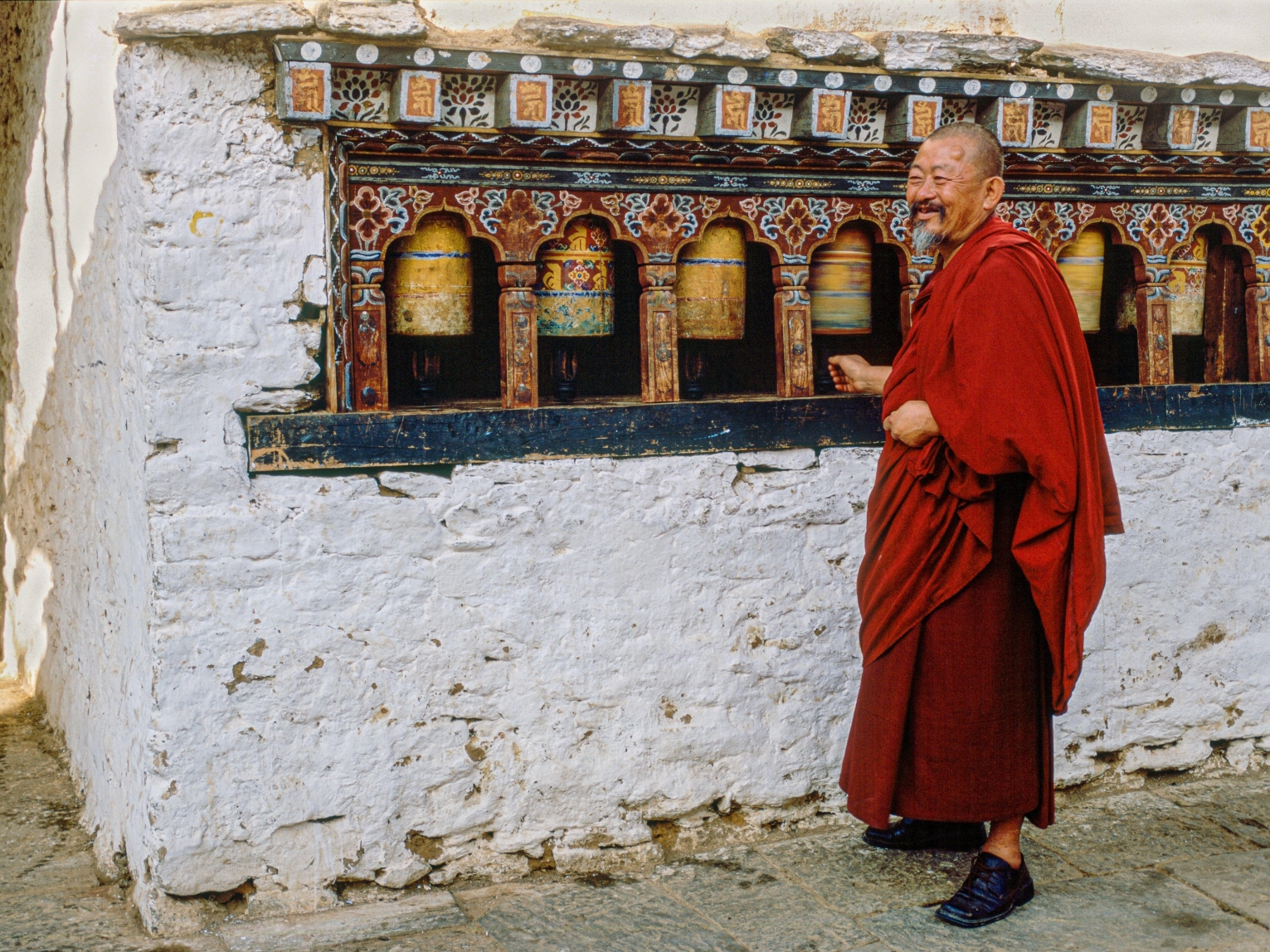 A Bhutanese monk spins a prayer wheel