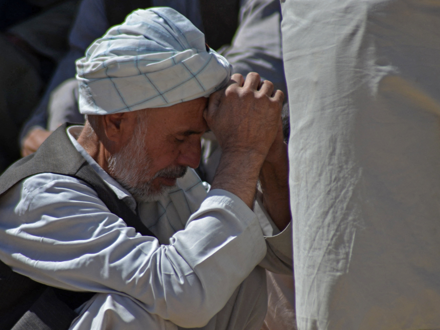 A man mourns the death of his relative at a graveyard in Kandahar on October 16, 2021.